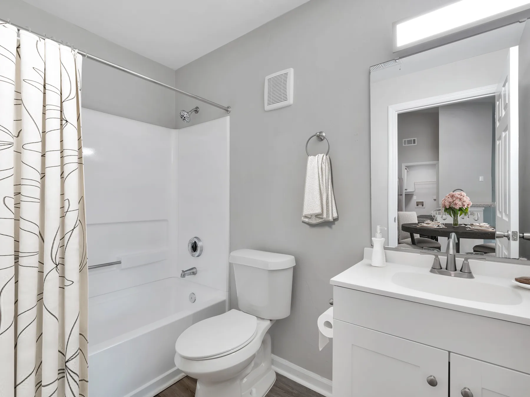 Bathroom with tub shower, white vanity and granite-style counter at Crescent Ridge