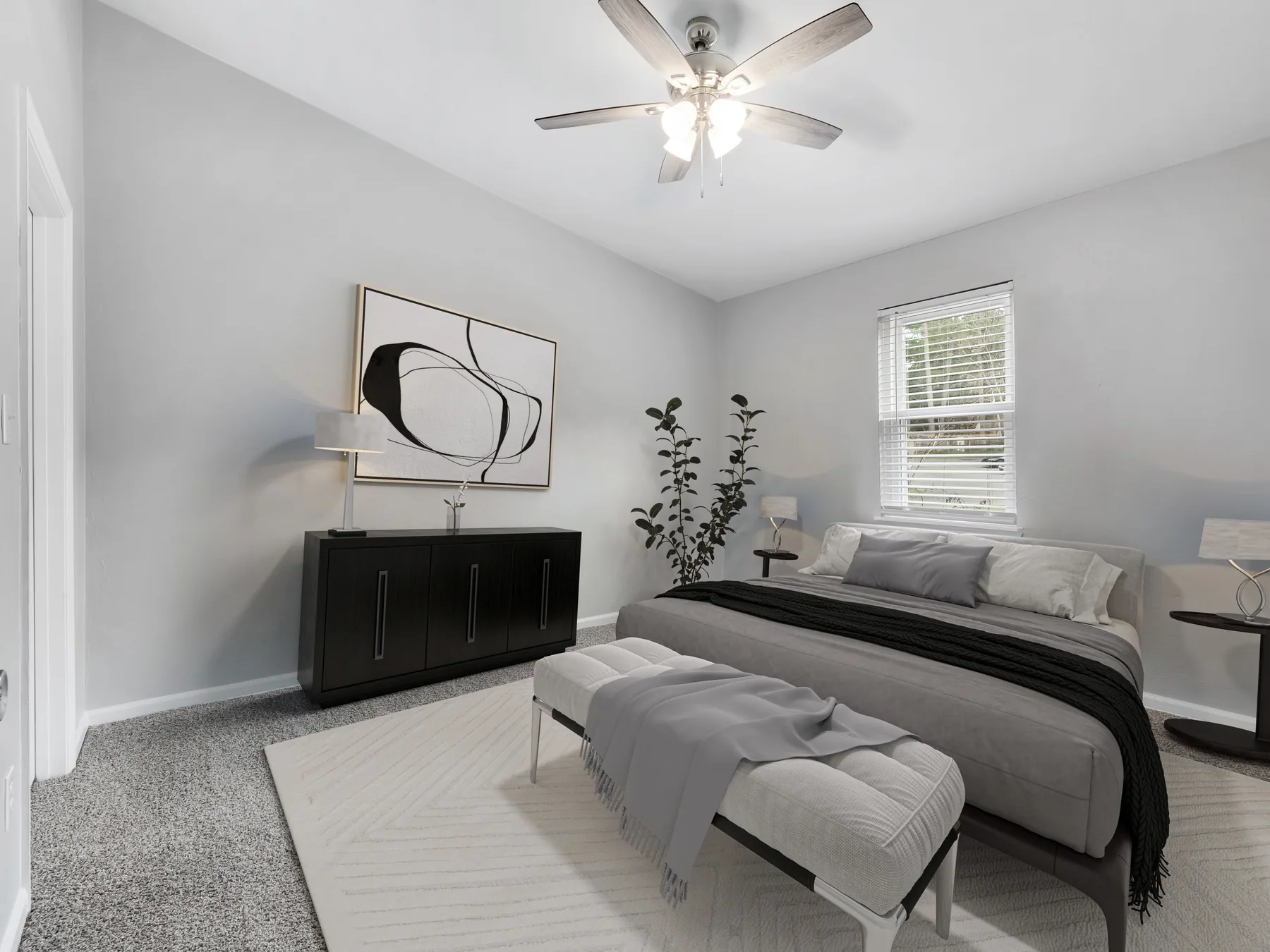 Staged primary bedroom with ceiling fan and window at Crescent Ridge Apartments