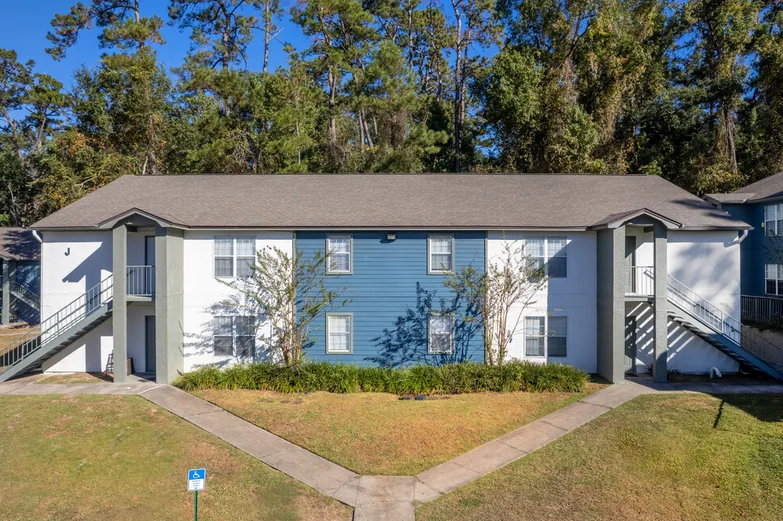 Two-story apartment building with exterior stairs and lawn at Crescent Ridge, Tallahassee